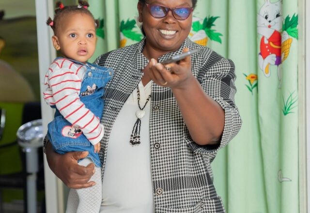 Staff member holding a happy baby at Josma Health children's hospital